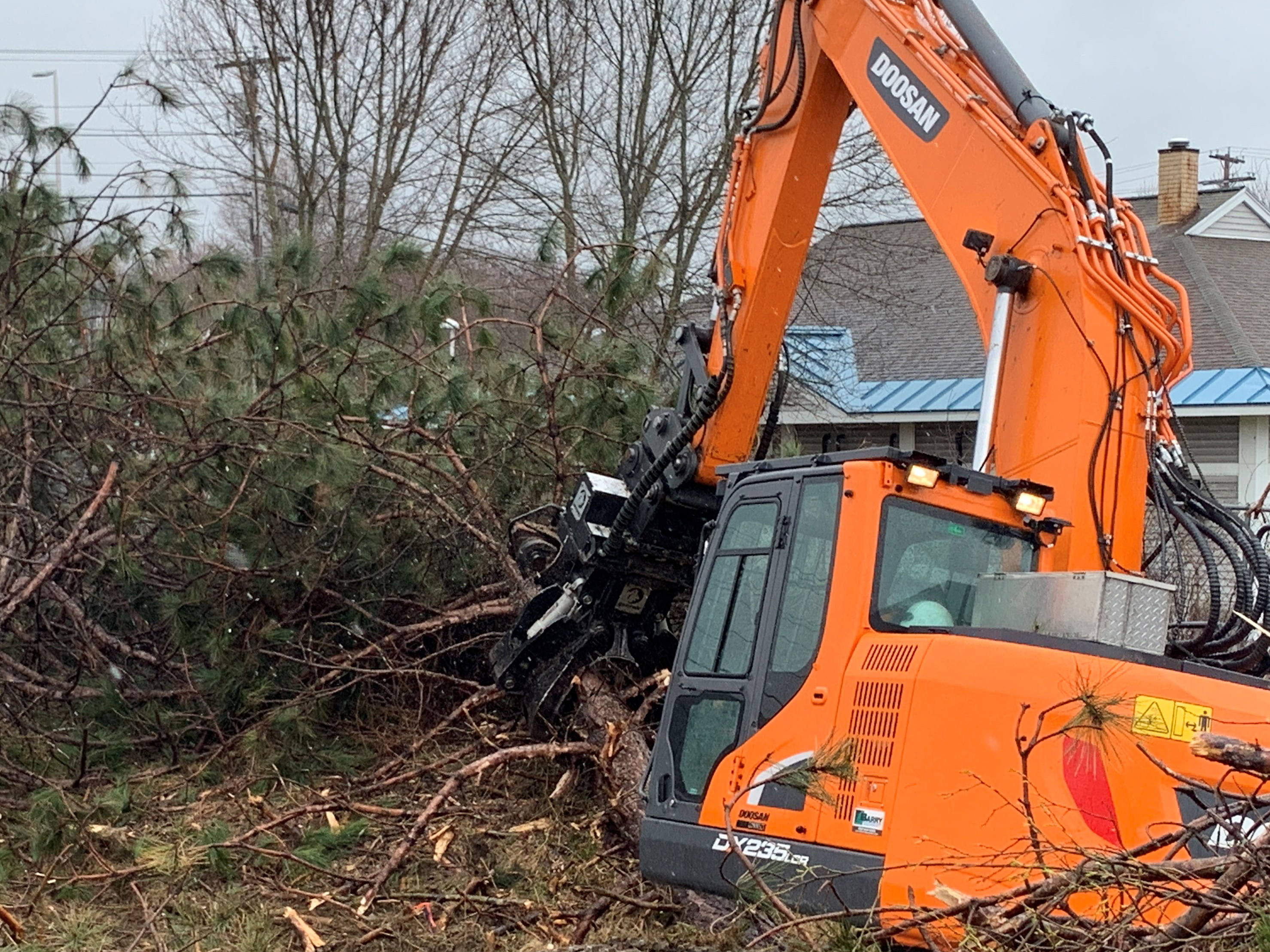 Backhoe clearing debris from project site